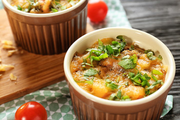 Ramekin with delicious sausage casserole on table, closeup