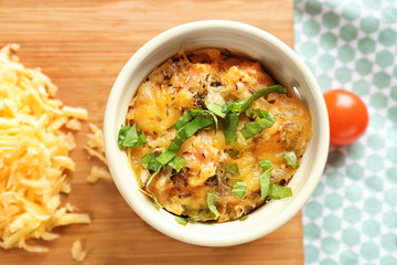Ramekin with delicious sausage casserole on table, closeup