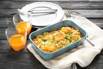 Delicious sausage casserole in baking dish on table