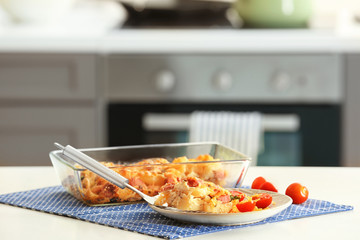 Delicious sausage casserole in kitchenware on table