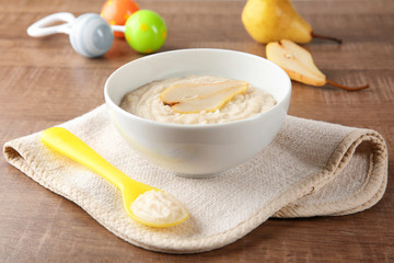 Bowl with porridge for baby on table