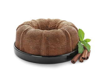 Plate with delicious cinnamon cake on white background