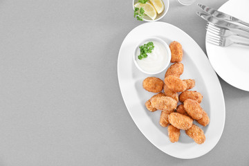 Plate with delicious salmon croquettes on table