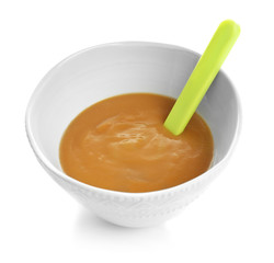 Bowl with baby food on white background