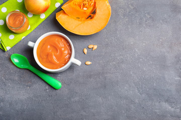 Bowl with baby food on grey background