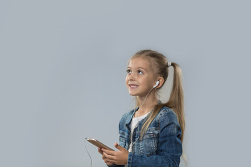 Beautiful Little Girl Using Smart Phone Listen Music Wear Earphones Happy Smiling Look To Copy Space Isolated Over Gray Background