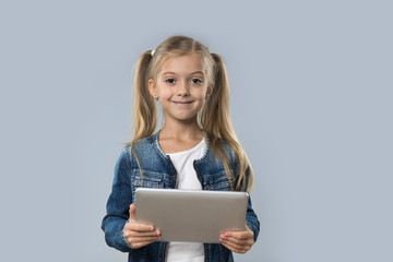 Naklejka premium Beautiful Little Girl Using Tablet Computer Happy Smiling Wear Jeans Coat Isolated Over Gray Background