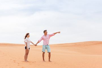 Young Man Woman In Desert Beautiful Couple Asian Girl And Guy Point Finger Sand Dune Landscape Background