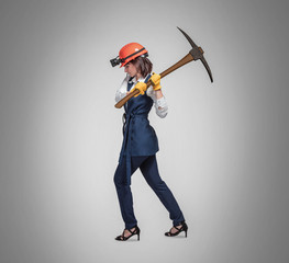 Naklejka premium Business woman with a pick on gray background. Studio shoot. Mining cryptocurrency concept