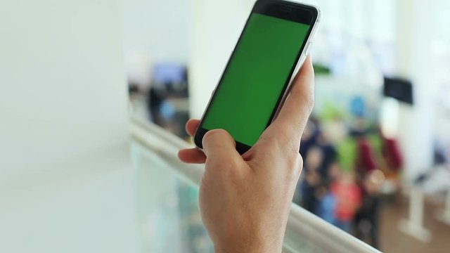 side view male holding smartphone applications green screen touchscreen mockup display close up blur people internet surfing e-business modern lifestyle checking news social network mobility concept