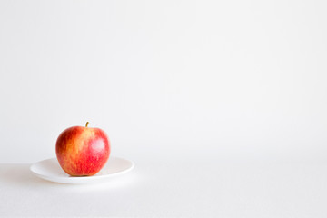 Fresh red apple on the plate in the kitchen. Healthy eating and lifestyle. Sweet fruit concept.