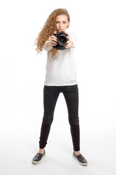 young girl with photo camera standing on white background