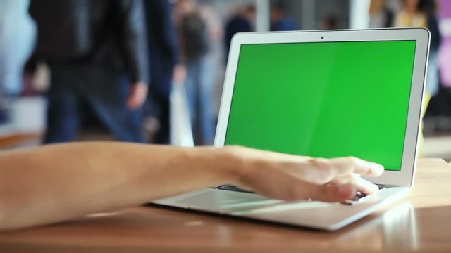 closeup man hand pointing button clicking keyboard working notebook laptop wooden table public workplace mockup green screen empty monitor internet education website chroma key chromakey network media