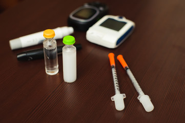 medicine, diabetes and health care concept - close up of blood sugar test stripe, glucometer,...