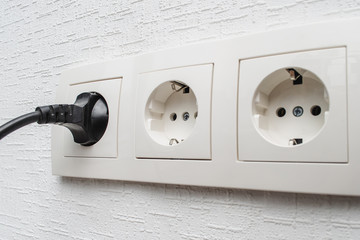 European set outlet on the wall with the plug inserted