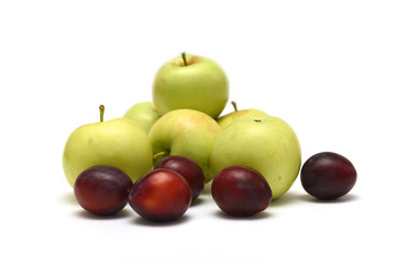 Plums and apples on white background
