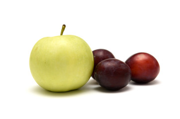 Plums and apples on white background