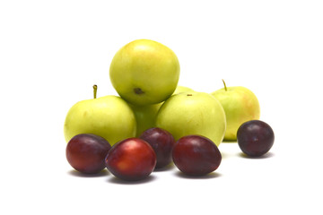 Plums and apples on white background