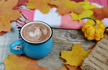 Blue Cup of Hot Chocolate, Plaid, Little Pumpkin and Yellow Leaves, Wooden Background, Autumn Concept