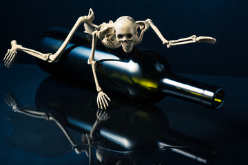 drunkard skeleton crawl on bottle with wine spill on floor