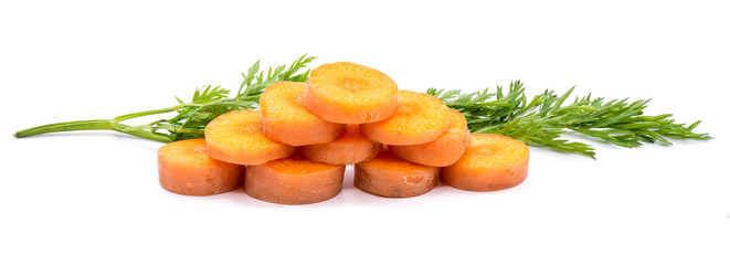 Group of sliced round orange carrot circles in the shape of pyramid with fresh green leaf isolated on white background