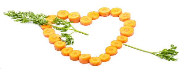 Group of sliced round orange carrot circles in the shape of heart and green leaves arrow isolated on white background