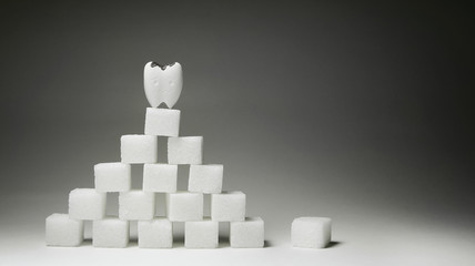 Pyramid of cubes sugar and Decayed teeth Model Standing on Top, If you eat a lot it warning Dental Healthy