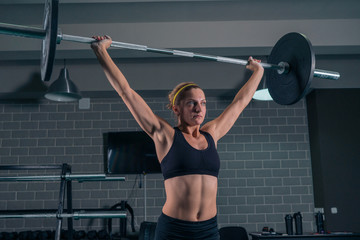 Athletic woman lifting a weight training at the gym. CrossFit