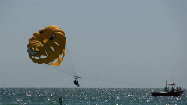 Vacation getaway adventure thrills parasailing in the Gulf of Mexico off Naples Florida.