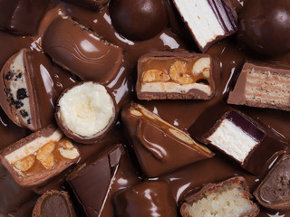 Different cut chocolate bars in melted chocolate, top ofview, close-up.