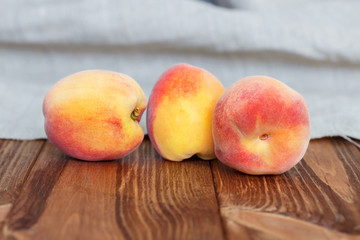 Fototapeta na wymiar Three peaches on a wooden board