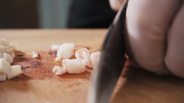 Cook hands is slicing of boiled squid. One of the stages of cooking calamaries. seafood restaurant top view
