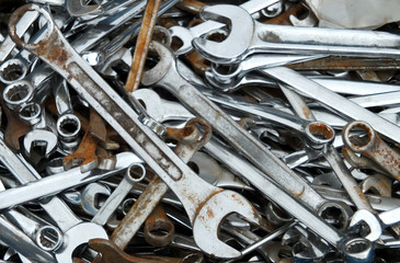 old rusty spanners and wrenches in a large pile in a toolbox