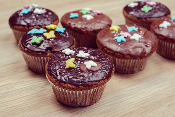 chocolate muffins on wooden ground