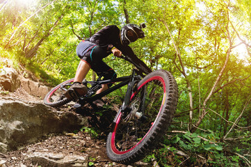 Fototapeta na wymiar Sport. A cyclist on a bike with a mountain bike in the forest