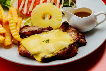Grilled pork steak French fries and sauce on White plate