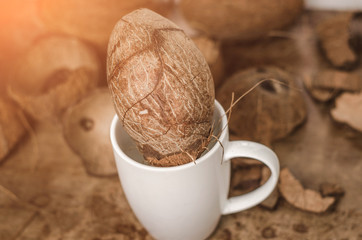 Tasty cocktail in white cup with coconut on wooden vintage table background