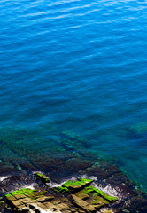 Fototapeta na wymiar Mediterranean sea, Greece, clean blue water lagoon. Beautiful sea shore, rocks, natural backdrop.