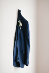 wedding bride jacket with boutonniere hanging on the wall