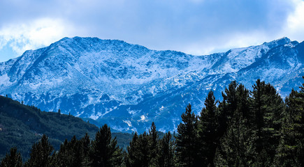 Naklejka na ściany i meble Photo depicting a beautiful moody frosty landscape. European alpine mountains with snow peaks on a blue sky background.