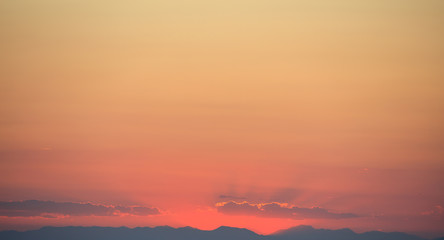 Beautiful sunset on sky over mountains background.