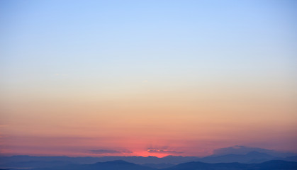 Fototapeta premium Beautiful sunset on sky over mountains background.