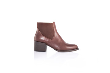 Close up of a women's brown leather chelsea boots on white background with reflection. Fashion...