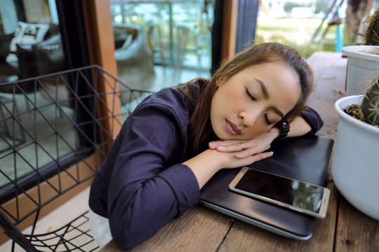 Businesswoman sleep relax on laptop after hard work in coffee shop