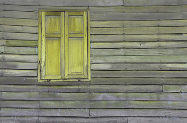The window of the old wooden log house on the background of wooden walls