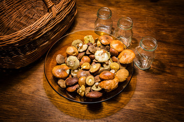 Glass plate with raw mushrooms.