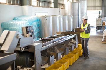 Female technician writing in clipboard
