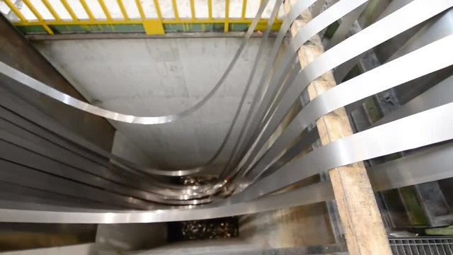 Steel cutter machine for coils with moving worker. Industrial environment, business concept.