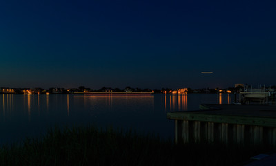 Fototapeta premium Dock, boat and marshes at sunset and blue hour off New Jersey inlet.