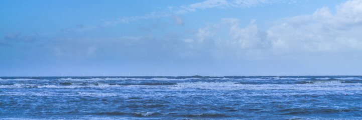 Naklejka na ściany i meble Wind turbines in the North Sea, view from the beach, panorama